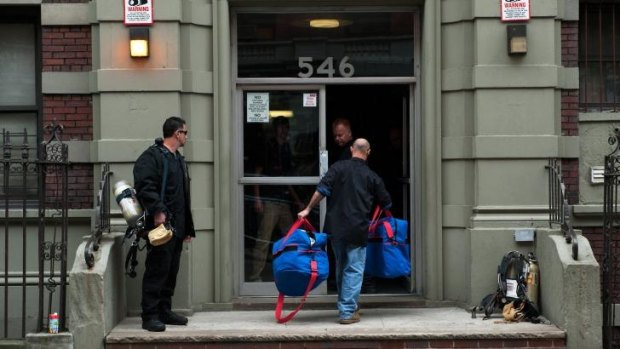 Employees from Bio Recovery Corporation carry equipment into 546 West 147th Street, the apartment building of Dr Craig Spencer.