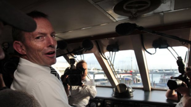 Tony Abbott at the helm of Green Island Reef Tours' big catamaran in Cairns this morning.