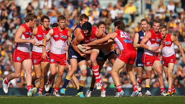 Swan Shane Mumford is tackled in the middle of a group during the game against West Coast.
