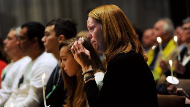 Miranda Pacchiana, centre, wipes her eye during a National Vigil for Victims of Gun Violence just prior to the first anniversary marking the Sandy Hook Elementary School mass shooting.