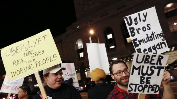 Demonstrators hold signs during a protest organised by the San Francisco Taxi Workers Alliance.