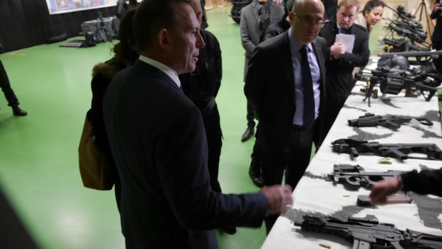 Australian prime minister Tony Abbott's inspects weapons at RAID's offices in France.