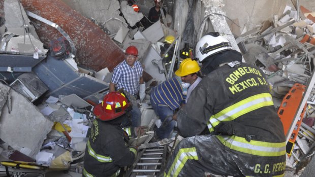 Firefighters dig for survivors after an explosion at an adjacent building to the executive tower of Mexico's state-owned oil company PEMEX, in Mexico City,
