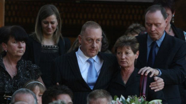 Anguish... David Grant, partner of Royal North Shore nurse Michelle Beets, helps comfort other friends and family at her funeral.