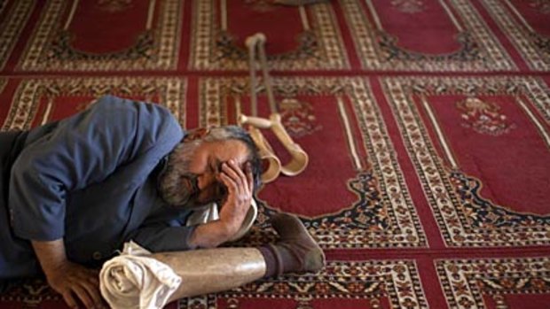 Not a leg to stand on... a man takes a nap with his prosthetic leg in between prayers at a mosque.