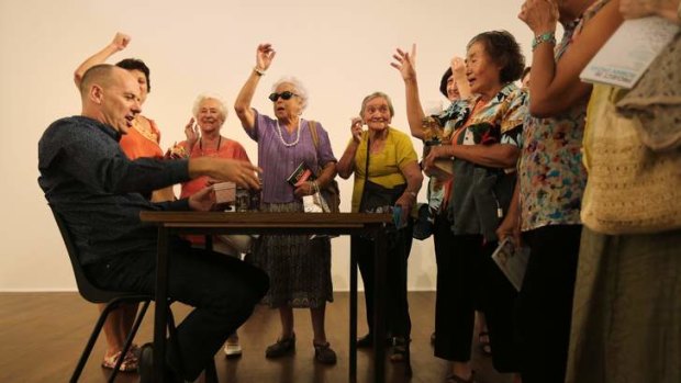 Performer Tony Osborne (left) in the Swap room negotiates a swap with a ladies cultural group from the Penrith area visiting Project 28: Roman Ondak.