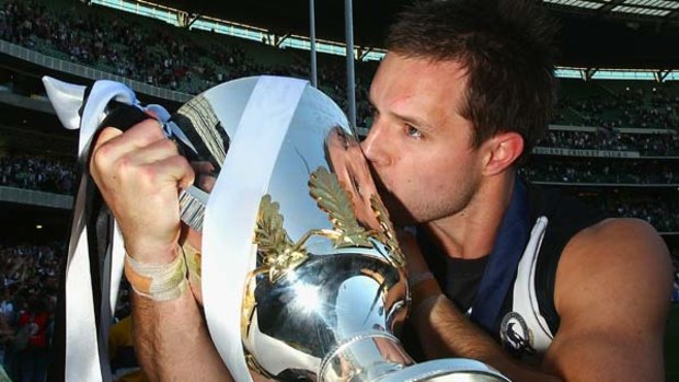 Nathan Brown of the Magpies kisses the premiership cup after the Magpies won the AFL Grand Final Replay.