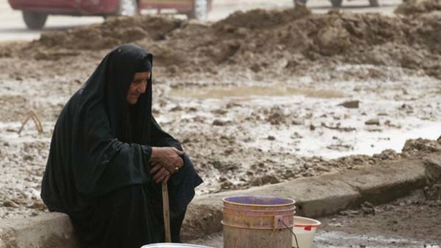 Water course … a woman sits by a well after collecting water in the Sadr City district of Baghdad.