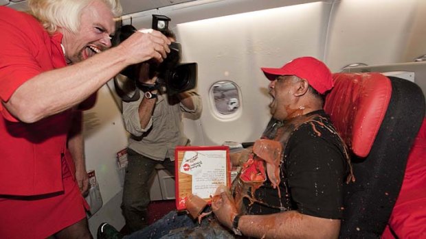 Richard Branson 'accidentally' spills a tray of drinks on AirAsia chief Tony Fernandes.