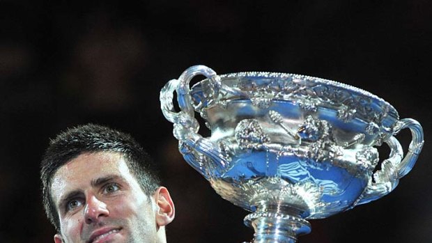 Novak Djokovic holds aloft the winner's trophy.