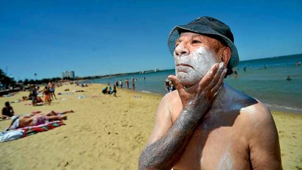 Rub it in: Chris Nesnas lathers on the sunscreen at St Kilda beach on Monday.