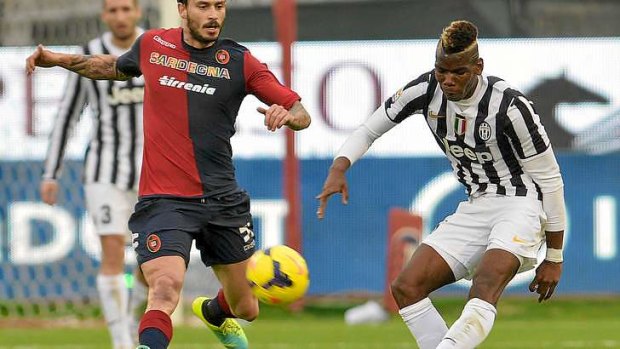Paul Pogba of Juventus passes past Cagliari's midfielder Daniele Dessena.