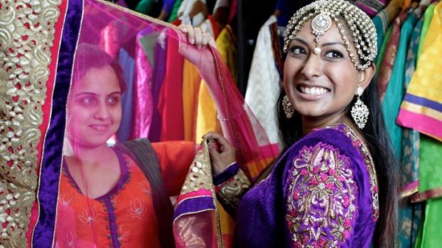 Shaleen Kumar, assisted by Tamanna Bajaj, tries on saris at Dulhan Exclusives in Liverpool, Sydney.