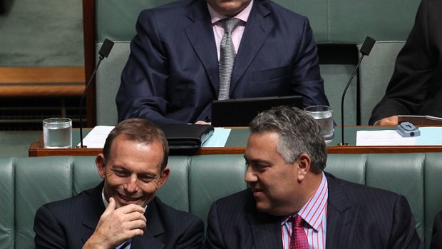 Tony Abbott and Joe Hockey share a moment in Parliament.