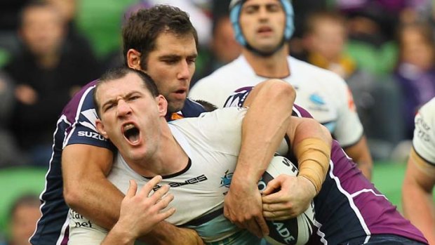 No way through ... Sharks captain Paul Gallen is tackled by Melbourne hooker Cameron Smith among others during the Storm's hard-fought victory at AAMI Park yesterday.