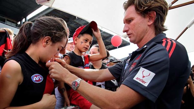 James Hird signs autographs at the Bombers' family day.