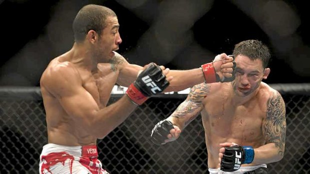 Jose Aldo connects with a left to Frankie Edgar's temple during their UFC 156 featherweight title bout.