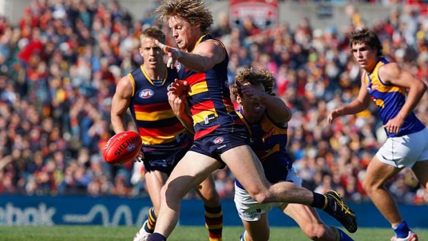 Rory, Rory, hallelujah: Rory Sloane boots the ball forward under pressure in the Crows' demolition of West Coast yesterday.