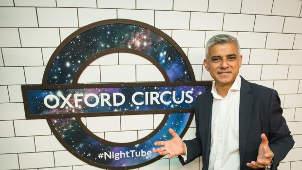 Mayor of London Sadiq Khan poses in front of a new Night Tube logo at Oxford Circus underground station.