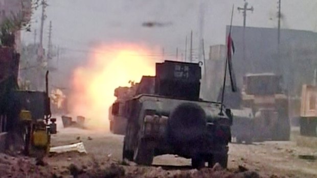 A tank opens fire during clashes in Fallujah on Sunday.