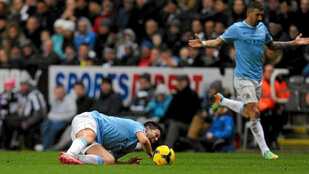 Samir Nasri of Manchester City collapes to the turf in agony.