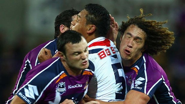 Rooster sandwiched: Joseph Leilua is crunched by three Storm players.