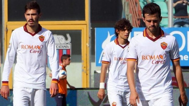Dejected Roma players  Alessio Romagnoli, Dodo and Miralem Pjanic leave the pitch after their loss to Sicilian club Catania.