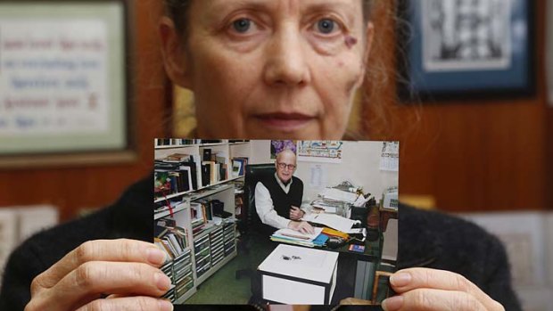Karen Short, wife of John, poses with a photo of her husband inside the Christian Book Room in Hong Kong.