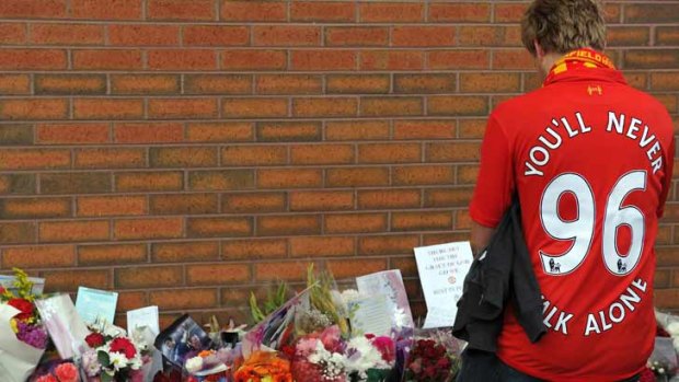 A supporter pays his respects outside to the 96 supporters who died in the 1989 Hillsborough disaster.