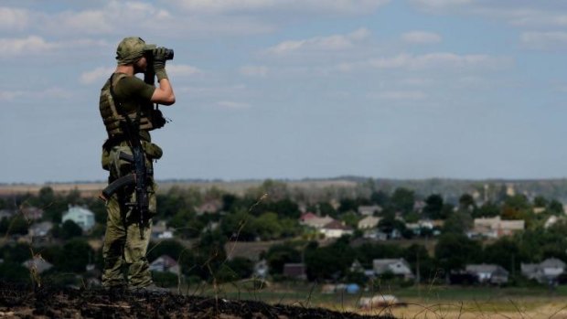 Standing guard: A Ukrainian fighter from the Azov Battalion on a hill on the outskirts of Mariupol on Saturday.