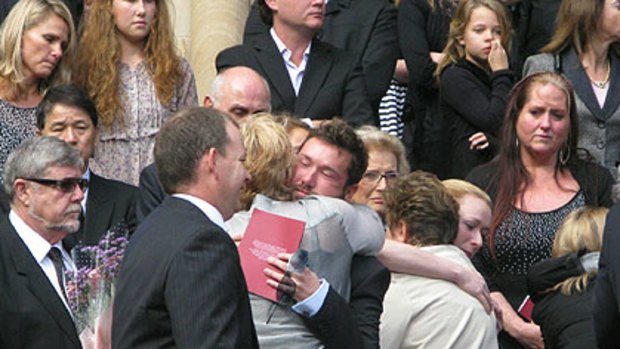 Mourners gather after the funeral.