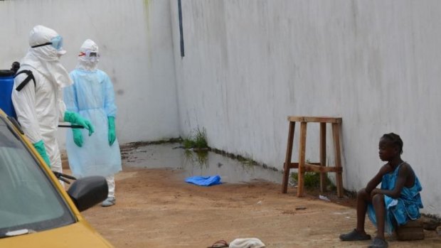 A girl cries after the death of her mother and father outside the Island Clinic, a new Ebola treatment centre in Monrovia.