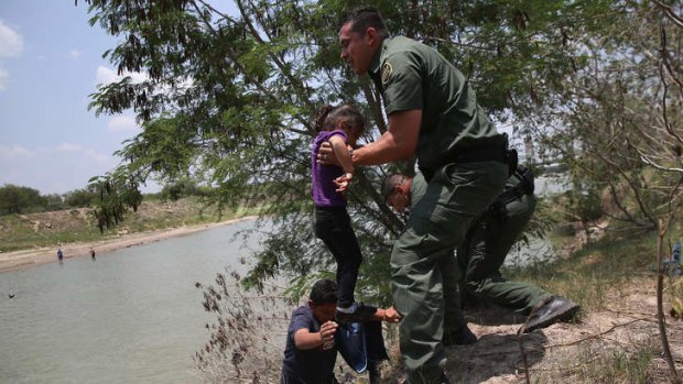 US Border Patrol agents help minors from El Salvador after they crossed the Rio Grande illegally into the United States.