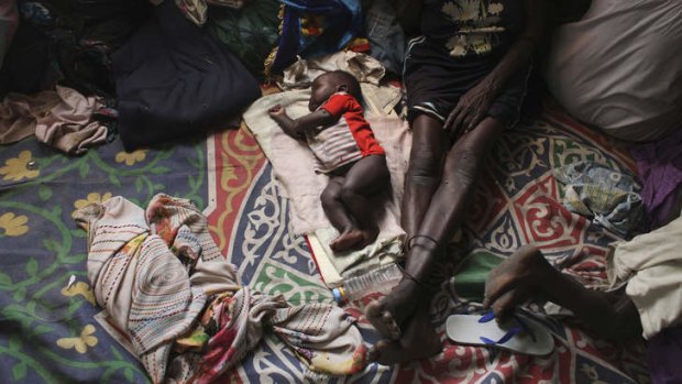 A baby sleeps next to a woman in a Catholic church in Malakal, South Sudan.