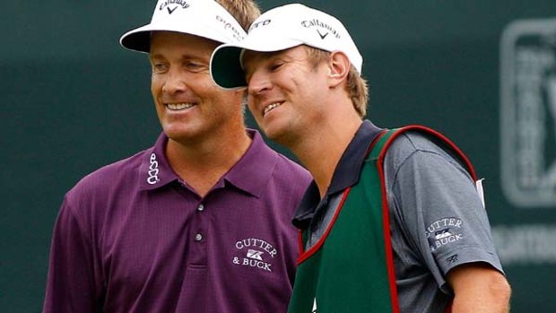 All smiles . . . Stuart Appleby celebrates with his caddie after his birdie on the 18th green.