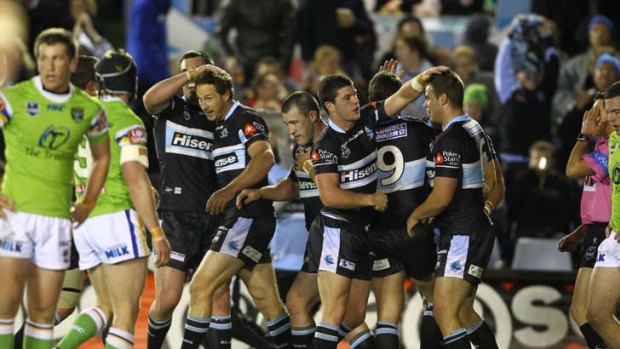 Personal best ... Colin Best, second from left, is congratulated by Cronulla teammates last night after crossing  the line at Toyota Stadium for his 100th NRL try. The Sharks won their fourth successive match.