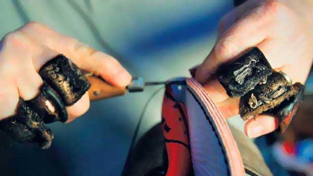 A hand-stitched Sherrin football in the making.