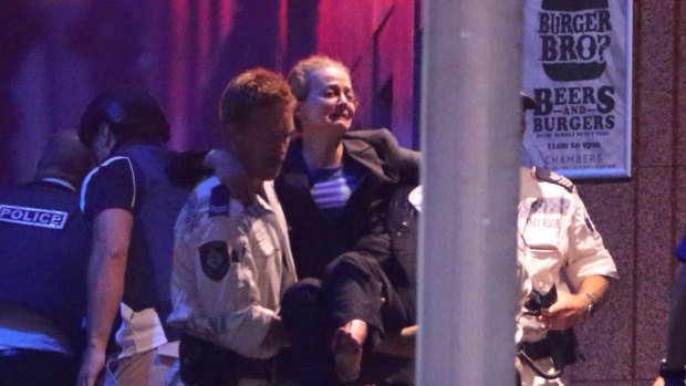 Hostage Marcia Mikhael is assisted from the Lindt Chocolat Cafe in Martin Place.