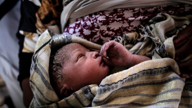 A new born baby girl lays in her mothers' arms right after being born onboard a Spanish rescue vessel on the Mediterranean Sea last month.