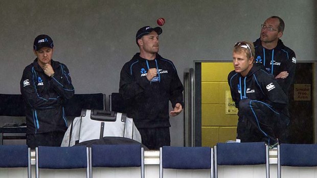 New Zealand captain Brendon McCullum (centre) watches the rain pour down at Dunedin with head coach Mike Hesson (left) and Neil Wagner (right, front).