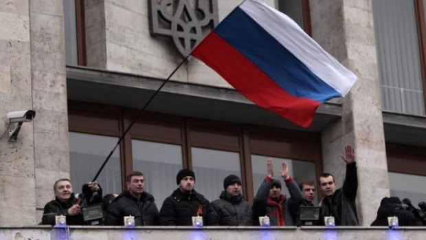 Pro-Moscow demonstrators fly a Russian flag from the balcony of the regional administrative building in Donetsk in eastern Ukraine.