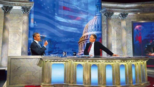 President Barack Obama talks with host Jon Stewart  gestures during a commercial break on The Daily Show