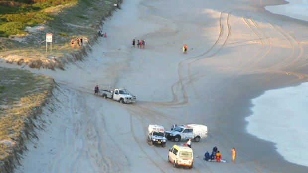Paramedics on the beach at South Ballina try unsuccessfully to revive a 44-year-old woman.