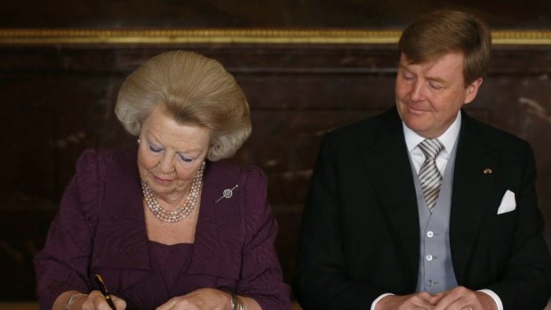 Changed times: Queen Beatrix of the Netherlands signs the Act of Abdication as her son and heir, now King Willem-Alexander, looks on in April 2013.