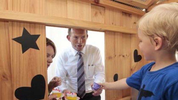 Opposition Leader Tony Abbott and Liberal candidate for Solomon have a tea party with Xavier Jones in a cubby house during a visit to the Mencshelyi household in the Darwin suburb of Lyons.