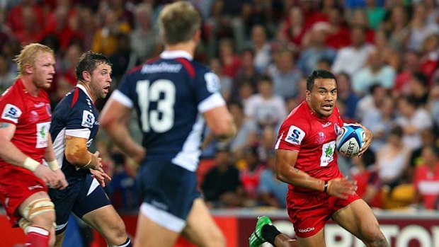 Bull at the gate . . . Digby Ioane of the Reds charges at the Rebels defenders in round five.