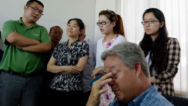 US businessman Chip Starnes who has been held hostage for six days over a wage dispute is surrounded by government officials and trade union leaders during a briefing at his Specialty Medical Supplies business in Huairou, Beijing on June 26, 2013.