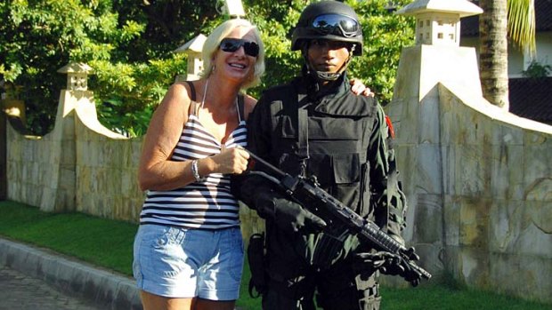 A tourist has her picture taken with an Indonesian army commando after a security exercise at a hotel in Bali.
