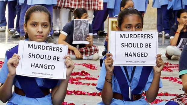 Call for the death penalty ... schoolgirls in Ahmadabad hold placards during a prayer ceremony to mourn the death of the rape victim.