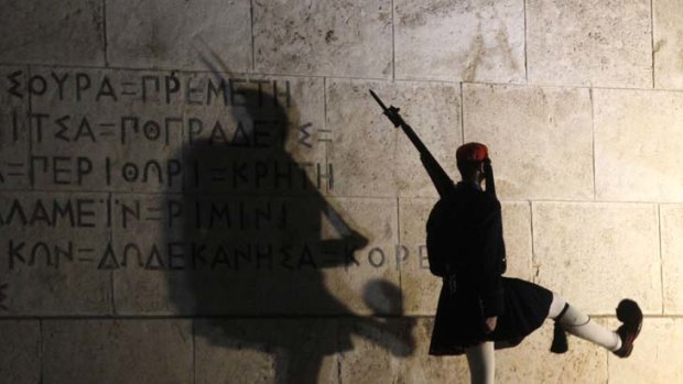 Nervous watch ... a presidential guard in Greece, whose membership of the euro zone is under threat.